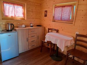 uma cozinha com uma mesa e um frigorífico numa cabina em Farm Stay Pr Lavric em Slivna