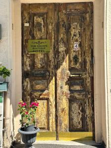 eine alte Holztür mit einem Schild drauf in der Unterkunft Tom Square Boutique Hotel in Istanbul
