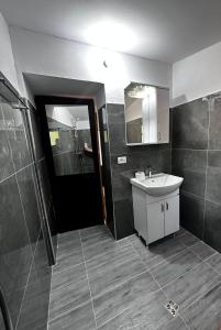 a bathroom with a sink and a mirror at Guest House Sakollari in Poliçan