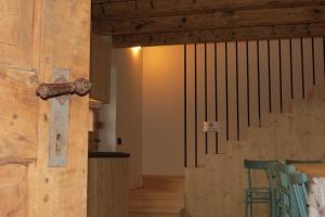 a wooden door with a bar in a room with chairs at Baita Misonet in Comano Terme