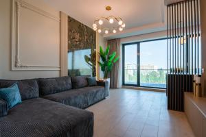 a living room with a couch and a large window at The 502 Mamaia in Mamaia