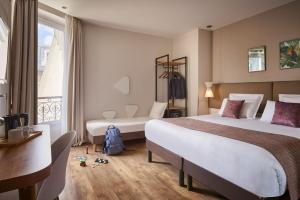 una camera d'albergo con due letti e una finestra di Hotel Magenta 38 by Happyculture a Parigi