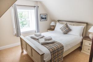 1 dormitorio con 1 cama con toallas en Greshornish House Hotel en Edinbane