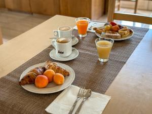 uma mesa com dois pratos de alimentos para o pequeno-almoço e duas chávenas de café em Agriturismo Masseria Cannella em Lesina