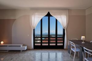 una camera con una grande finestra con tavolo e sedie di Villa 70 a Peschiera del Garda