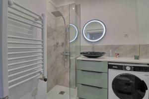 y baño con ducha y lavadora. en Accès direct Promenade Des Anglais - Negresco, en Niza