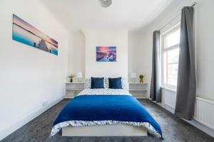a white bedroom with a blue bed in it at Luxury Liverpool Accommodation in Liverpool