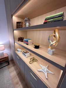 un estante con una estrella de mar y libros en una habitación en Shelter Luxury Apartament en Rogowo