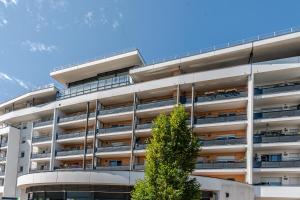 an apartment building with a tree in front of it at OVELIA Seynod - Les Balcons d'Annecy in Annecy