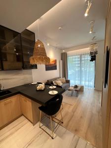 cocina y sala de estar con encimera negra en Shelter Luxury Apartament en Rogowo