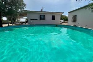 a large blue swimming pool in front of a house at CasaMè - Villa Castelli in Villa Castelli