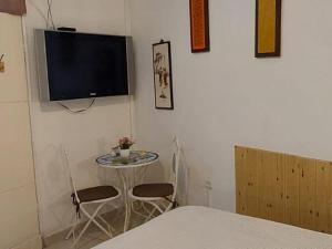 Cette chambre dispose d'une table et d'une télévision murale. dans l'établissement Spring apartment Bahar nissim Jerusalem, à Jérusalem