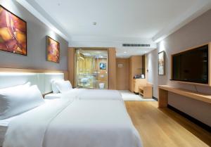 a bedroom with two white beds and a flat screen tv at Guangzhou Ming Yue Hotel in Guangzhou