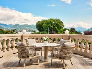 a patio with a table and chairs on a balcony at Boutique Hotel Stresa in Stresa