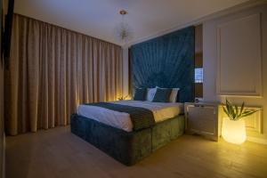 a bedroom with a large bed with a blue headboard at The 502 Mamaia in Mamaia