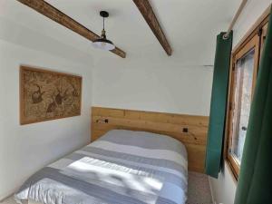 een slaapkamer met een bed in een kamer met een raam bij Le Nid des Amis -Villa, jardin, vue à la montagne in Saint-Auban
