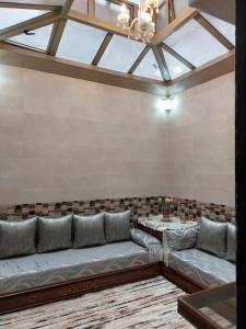 ein Wohnzimmer mit einem langen Sofa und einem Tisch in der Unterkunft Luxurious Holiday Home in Temara