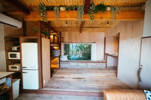 cocina con nevera y suelo de madera en Villa Yumigahama, en Minamiizu