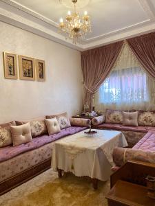 a living room with a purple couch and a table at Luxurious Holiday Home in Temara