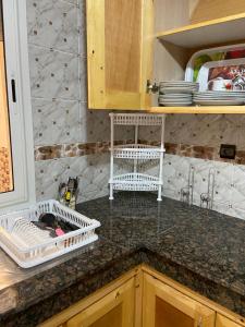 a kitchen counter with white dish drying racks on it at Luxurious Holiday Home in Temara