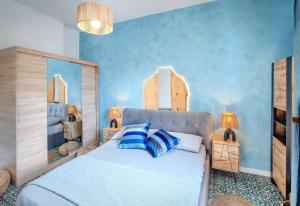 - une chambre avec un grand lit aux murs bleus dans l'établissement Dipinto di Blu by PortofinoVacanze, à Rapallo