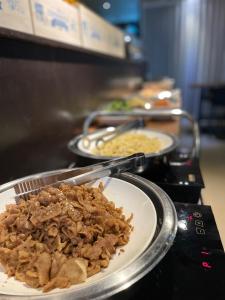 une assiette de nourriture sur un comptoir avec d’autres denrées alimentaires dans l'établissement Benikea Jungmun Hotel, à Seogwipo