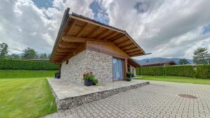 a stone house with a wooden roof at Boutique Holiday Pirin Golf in Razlog