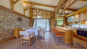 a kitchen with a table and chairs and a stone wall at Boutique Holiday Pirin Golf in Razlog