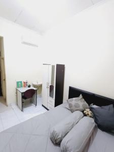 Schlafzimmer mit einem Bett, einem Schreibtisch und einem Waschbecken in der Unterkunft Kost Griya Asri by ecommerceloka in Jakarta