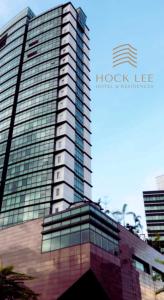 a tall building with glass windows on top of it at Hock Lee Hotel & Residences in Kuching