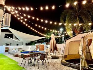 a patio with a tent and a table and chairs at Klebang Melaka Private Pool 12pax-4BR-Sing K-Coway in Melaka