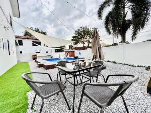 un patio con mesa, sillas y piscina en Klebang Melaka Private Pool 12pax-4BR-Sing K-Coway en Melaka