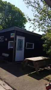 a black shack with a picnic table in front of it at La Luna - Desi in Heerhugowaard