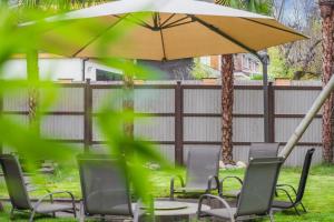 a table and chairs under an umbrella in a yard at LARGE COSY HOME @ WENTWORTH, SUNNINGDALE, ASCOT in Sunningdale