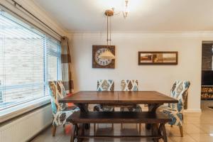 a dining room with a wooden table and chairs at LARGE COSY HOME @ WENTWORTH, SUNNINGDALE, ASCOT in Sunningdale