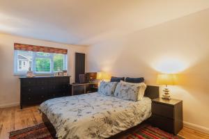 a bedroom with a bed with a dresser and a window at LARGE COSY HOME @ WENTWORTH, SUNNINGDALE, ASCOT in Sunningdale