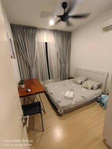 a bedroom with a bed and a table and a ceiling fan at HOT@Sunway Citrine!Spacious BR+360 RT seaview in Kampong Pendas