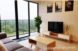 sala de estar con TV de pantalla plana y ventanas grandes. en HOT@Sunway Citrine!Spacious BR+360 RT seaview en Kampong Pendas