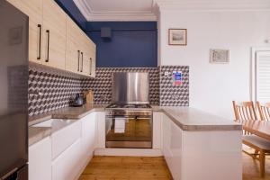 a kitchen with white cabinets and a stove top oven at ALTIDO Splendid 2bed apt near Haymarket in Edinburgh