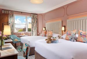 Dos camas en una habitación de hotel con dos ositos de peluche. en Waterloo Town House & Suites, en Dublín