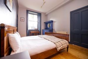 a bedroom with a bed and a blue door at JOIVY Splendid 2bed apt near Haymarket in Edinburgh