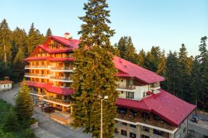 een groot gebouw met een rood dak bij Musala Hotel in Borovets