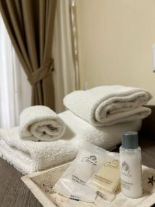 a bathroom with towels and a bottle of lotion at 55 Aira Hotel in Palermo