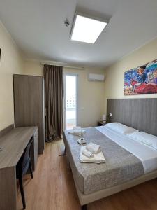 a bedroom with a bed and a desk and a window at 55 Aira Hotel in Palermo