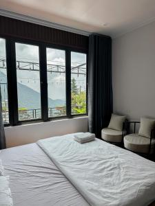 a bedroom with a large bed and a window at Bách Xanh House in Tam Ðảo