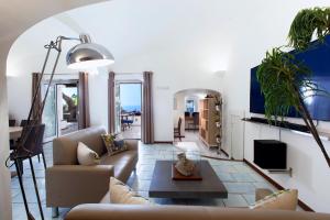 a living room with a couch and a table at Faraglionensis MonaconeHouse Villa in Capri
