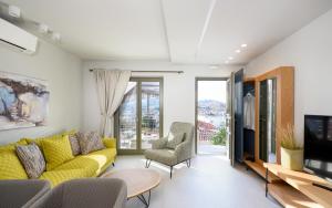 a living room with a yellow couch and a tv at Kale Alti residences in Myrina