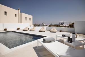 a patio with a pool and chairs and a swimming pool at Ciel Milos in Adamantas