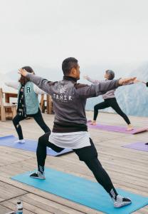 un gruppo di persone che fanno yoga in una lezione di yoga di Tenir Eco Hotel, Shymbulak Mountain Resort a Almaty