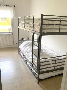 Ce dortoir comprend 2 lits superposés et une fenêtre. dans l'établissement Gullringens Värdshus & hotell, à Gullringen